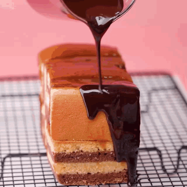 a piece of cake is being covered in chocolate