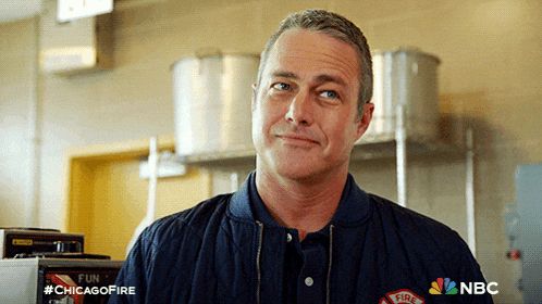 a man wearing a chicago fire jacket smiles in a kitchen