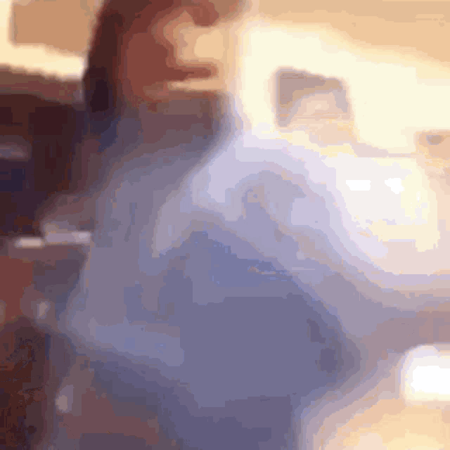 a blurry picture of a woman in a blue sweater .