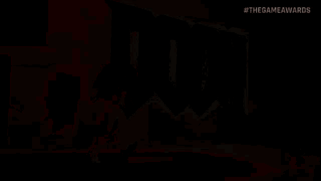 a man is walking in front of a large screen that says doom
