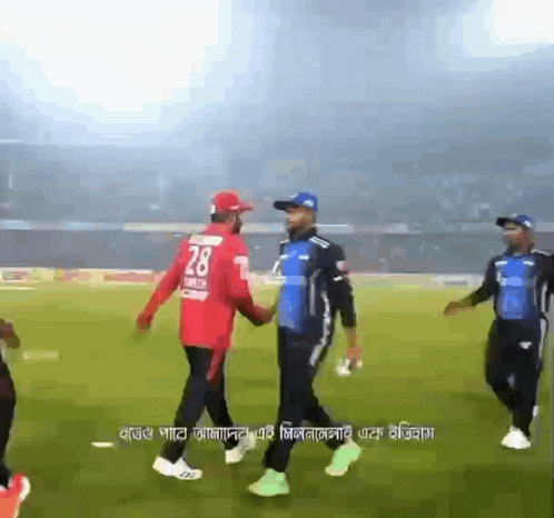 player number 28 shakes hands with another player on a field