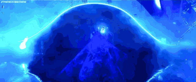a jellyfish is swimming in a dark blue tank with a light coming out of it .