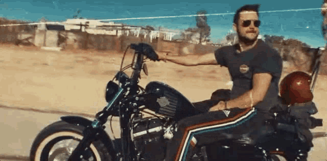 a man is riding a harley davidson motorcycle on a dirt road .