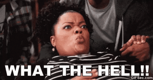 a woman is making a funny face while holding a man 's hand and says what the hell .