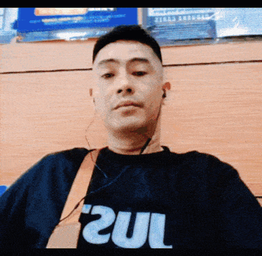 a man wearing ear buds and a shirt that says zul