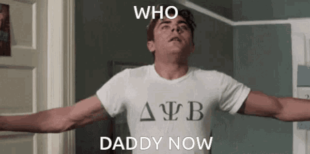 a man with his arms outstretched is wearing a white shirt that says daddy now