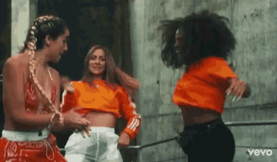 a group of women are standing next to each other and dancing .