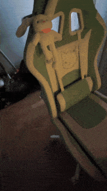 a green and white chair with a stuffed bunny on it