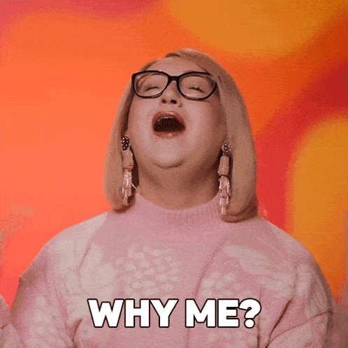 a woman with glasses and a pink sweater says " why me "