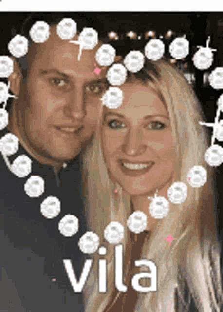 a man and a woman are standing next to each other in front of a heart with the name vila written on it .