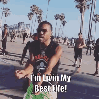 a man is dancing on a beach and saying i 'm livin my best life