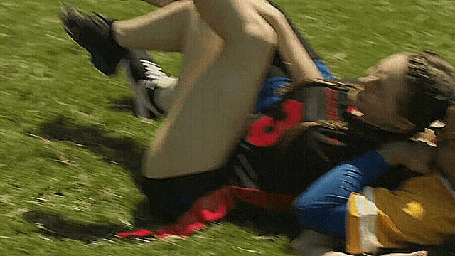 a person wearing a red number 8 jersey is laying on the grass