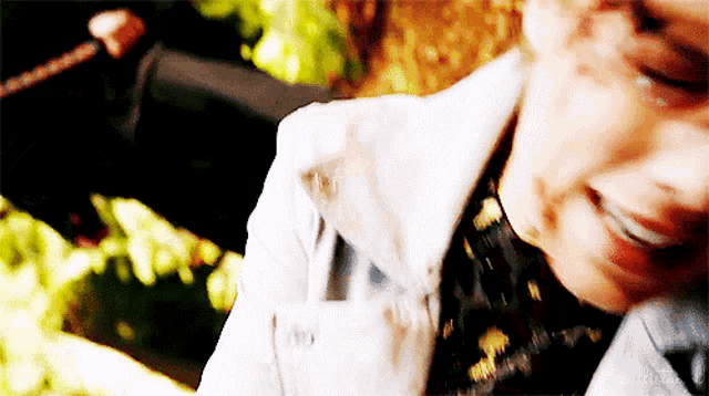 a close up of a person 's face with a white jacket on