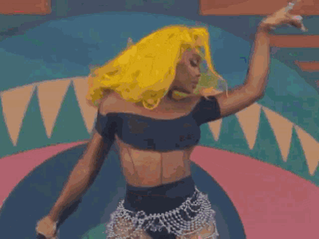 a woman with bright yellow hair is dancing in front of a colorful background