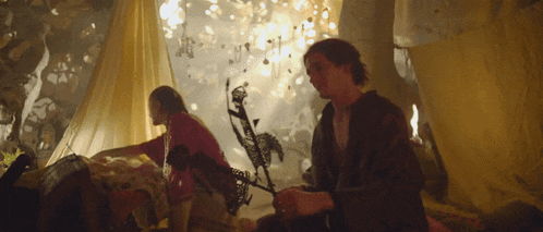 a man and a woman are sitting in a tent with a lot of lights