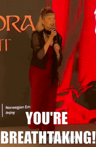 a woman singing into a microphone with the words " you 're breathtaking " on the bottom