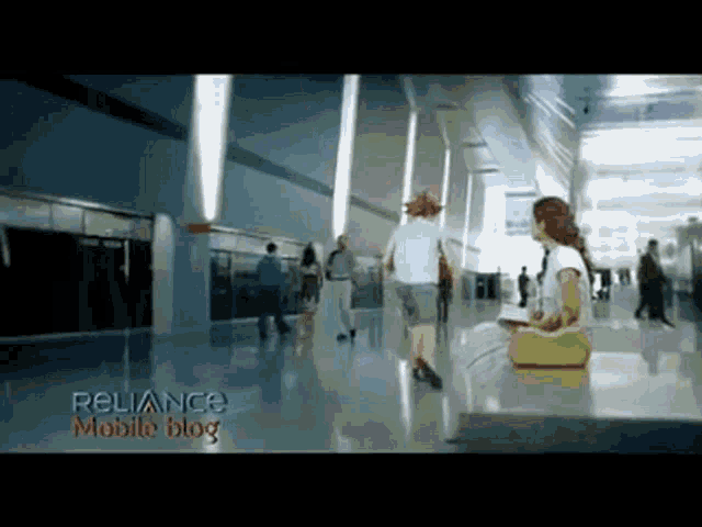 a woman sits on a bench in a hallway with a reliance mobile blog advertisement on the bottom