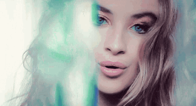 a close up of a woman 's face with a blue background