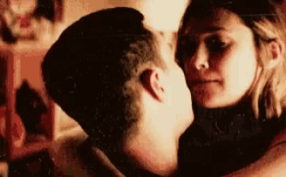 a man and a woman are kissing and hugging each other .
