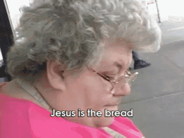 an elderly woman wearing glasses and a pink shirt says jesus is the bread
