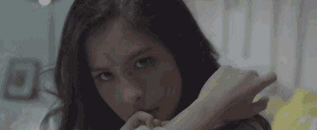 a close up of a woman 's face with a yellow blanket in the background