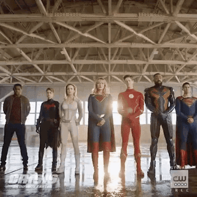 a group of superheros are standing next to each other in a building .