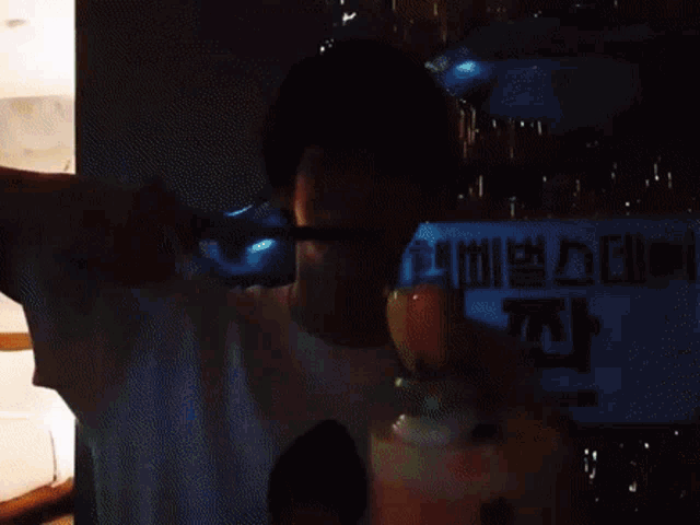 a man is blowing out candles on a cake in front of a sign that says ' korean '