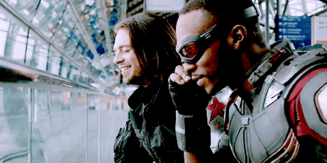 two men in superhero costumes are sitting next to each other
