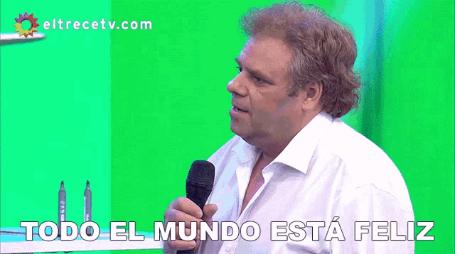 a man holding a microphone with the words todo el mundo esta feliz below him