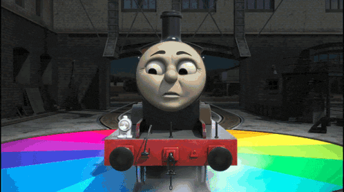 a train with a sad face is on a rainbow colored track