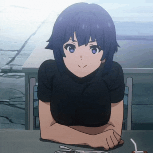 a girl is sitting at a table with her hands folded