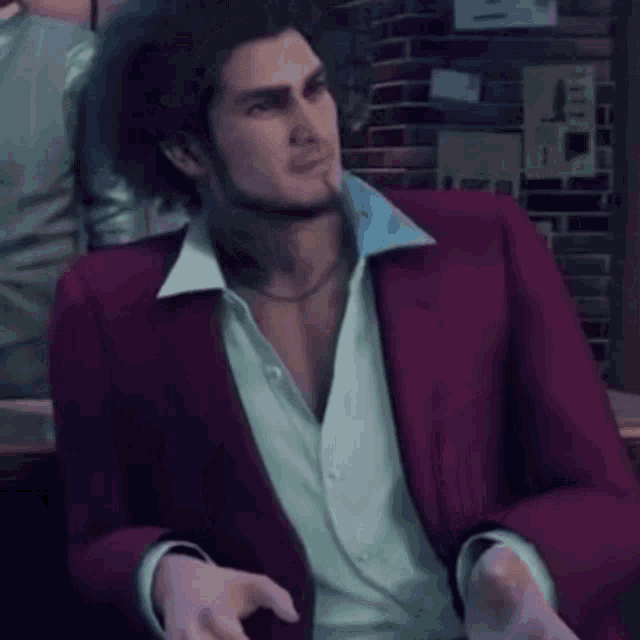 a man in a red jacket and white shirt is sitting in front of a brick wall .