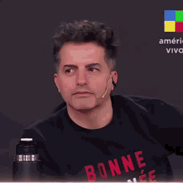 a man wearing a black shirt that says bonne on the front