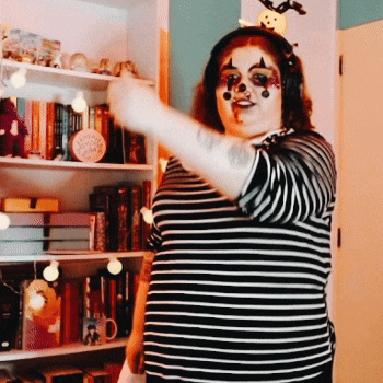 a woman in a clown costume is wearing headphones and a headband with a pumpkin on it