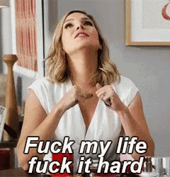 a woman is sitting at a table with her hands in her pockets and says fuck my life fuck it hard .