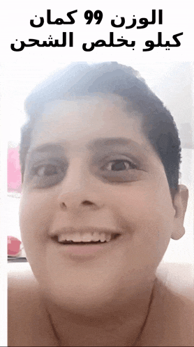 a boy with black spots on his eyes is smiling with arabic writing behind him