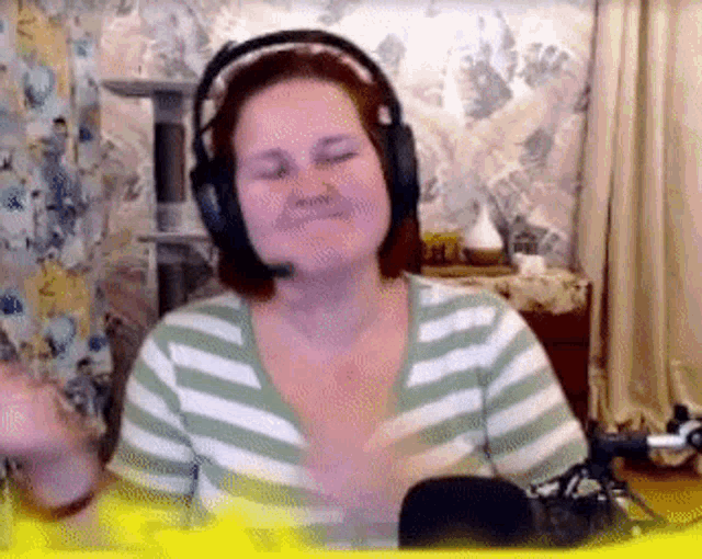 a woman wearing headphones and a striped shirt is smiling