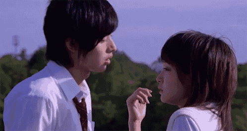 a boy and a girl are looking at each other .