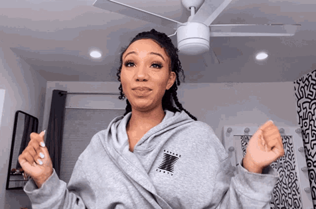 a woman wearing a grey sweatshirt with the letters x on it