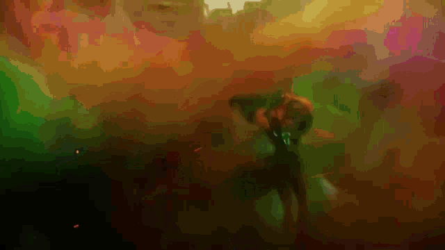 a man in a green shirt is dancing in a crowd of people in a dark room