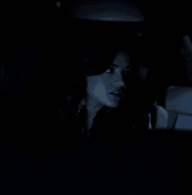 a woman sitting in a car with her eyes closed