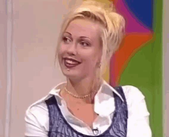 a woman with blonde hair is smiling and wearing a necklace