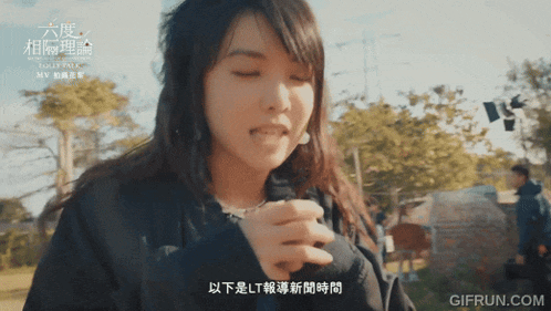 a woman with chinese writing on her face is holding something in her hand
