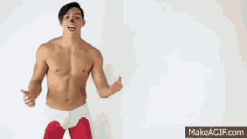 a shirtless man is wearing red and white pants and a nose ring .