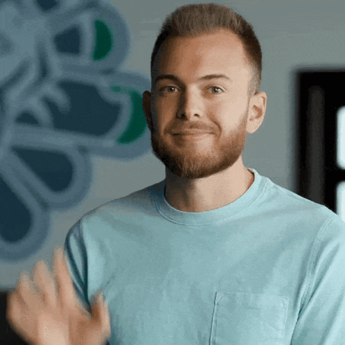 a man with a beard is wearing a blue shirt and smiling