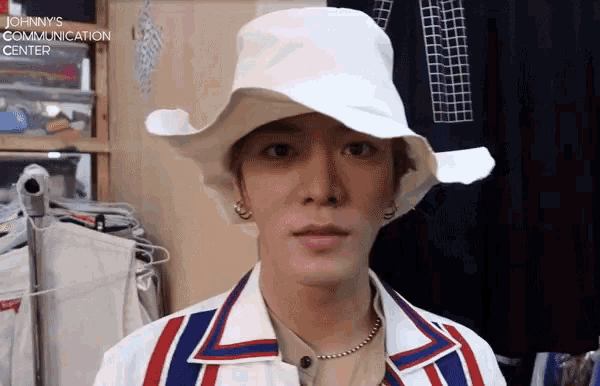 a man wearing a white hat with the words johnnys communication center on the bottom