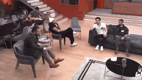 a group of men are sitting on a couch in a living room .