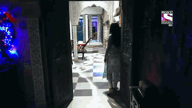 a woman is standing in a dark room with a sony logo on the bottom