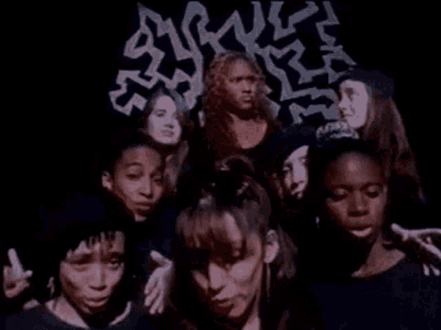 a group of young women are standing next to each other in front of a maze .