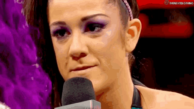 a woman is talking into a microphone while wearing a headband .